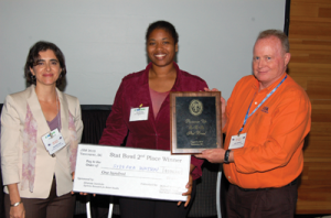 Cavell Brownie Scholar Sydeaka Watson (center) receives her Stat Bowl second-place award from Stephanie Cano and Mike Anderson.