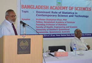 Shahjahan Khan (standing) speaks during a statistics seminar while BSA president, Mesbahuddin Ahmad (sitting), listens at the Bangladesh Academy of Sciences. 