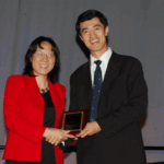 Xihong Lin presents the COPSS Presidents' Award to Samuel Kou.