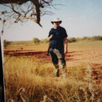 Clyde Martin stands in a field in what looks like Africa, but is really Lubbock, Texas.