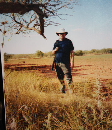 Clyde Martin stands in a field in what looks like Africa, but is really Lubbock, Texas.