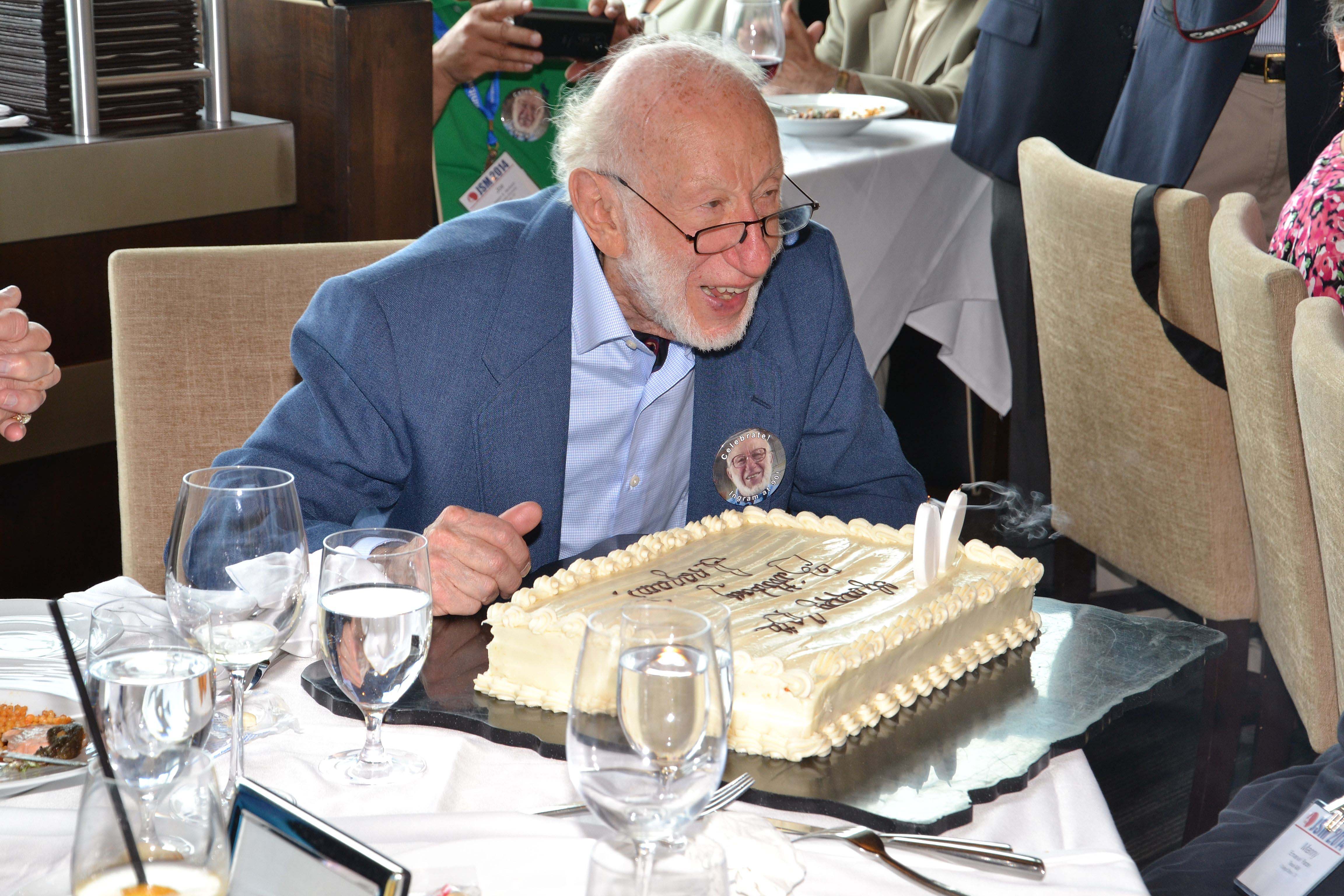Ingram Olkin reads what is written on his 90th birthday cake