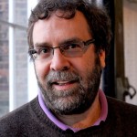 Photo of Nicholas Horton, a white man with a beard, glasses, and short curly hair
