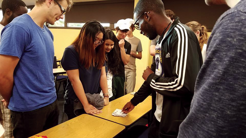 Members split into groups so they can play cards. Samuel Mirtil demonstrates an interactive card-counting system and participants collectively count according to the methods just learned.