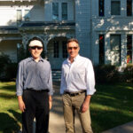 Terry Katz (wearing hat) stands next to Clifton Truman Daniel, the oldest grandson of President Harry Truman, in front of the Truman home in Independence, Missouri.