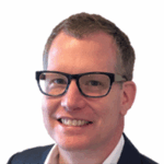 Photo of Richard Zink, a white man smiling and wearing black framed glasses.