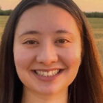 Headshot of an Asian woman with long, straight dark hair. She is smiling.