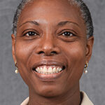 A headshot of a black woman with short salt-and-pepper hair smiles.