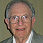 A white man with a receeding hairline and gray hair wearing glasses