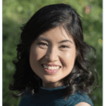 Po-Ling Louh, big smile, dark hair, background of photo is outdoors.