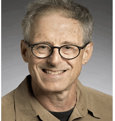 Robert Kass, Glasses, button down shirt, no tie, smiling.