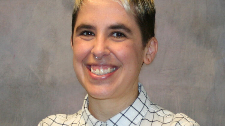 Photo of Yates Coley, Big smile, short hair, striped button down shirt.