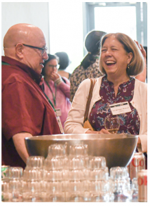 Ron and Jeri stand in front of a punch bowl laughing.