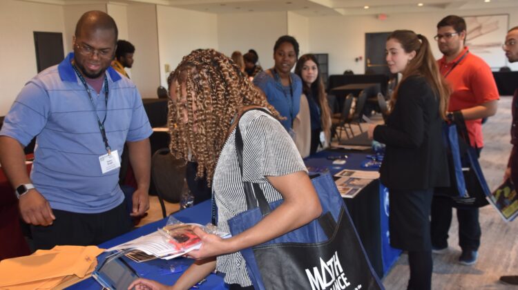 Attendees pick up their materials at the Field of Dreams Conference Graduate Fair registration table. Photo by Donald Cole