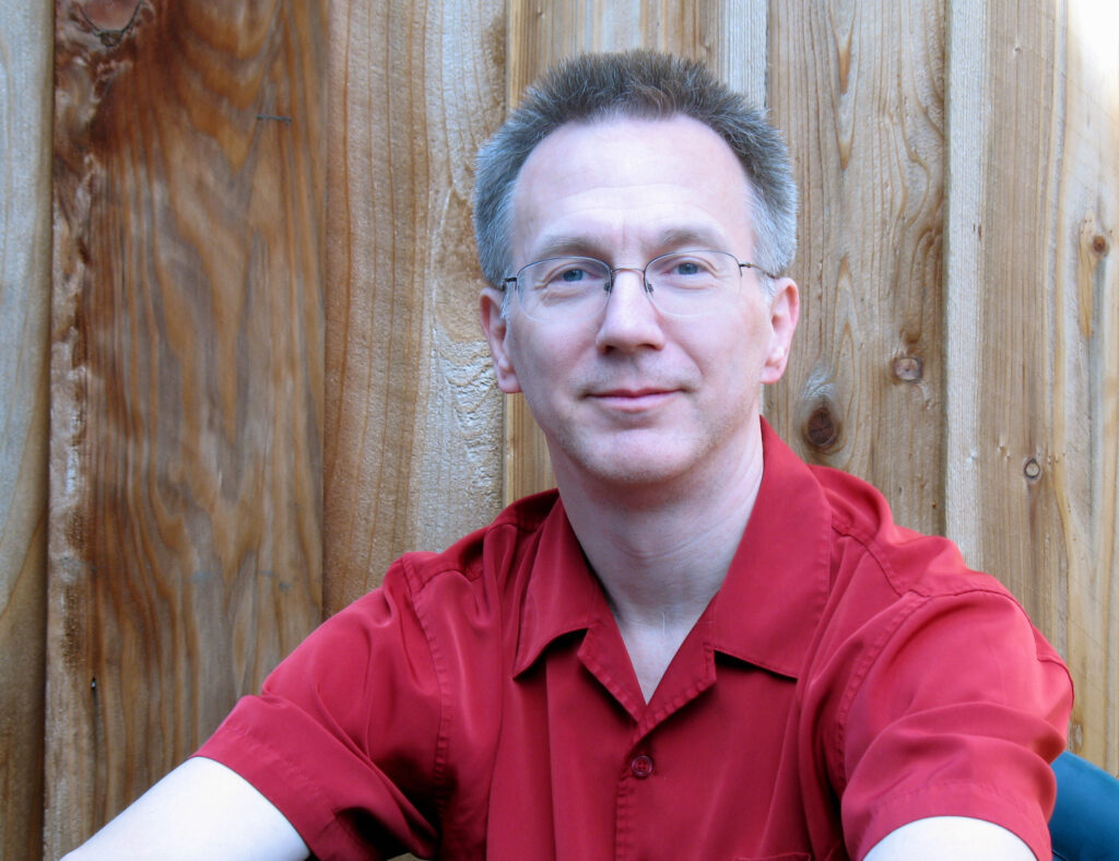 Photo of Dana Mackenzie, glasses, short hair, short-sleeve shirt.