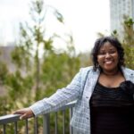 A photo of Afia Owusu-Forfie. She is outdoors and has shoulder length hair, and wears a button down jacket