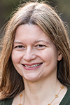 White woman with long brown hair with a big smile