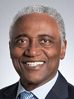 A Black man with short gray hair smiles