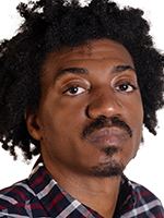 A Black man with kinky hair and a mustache and goatee