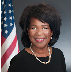 Portrait of Peggy Carr, a Black woman with short hair wearing a string of pearls