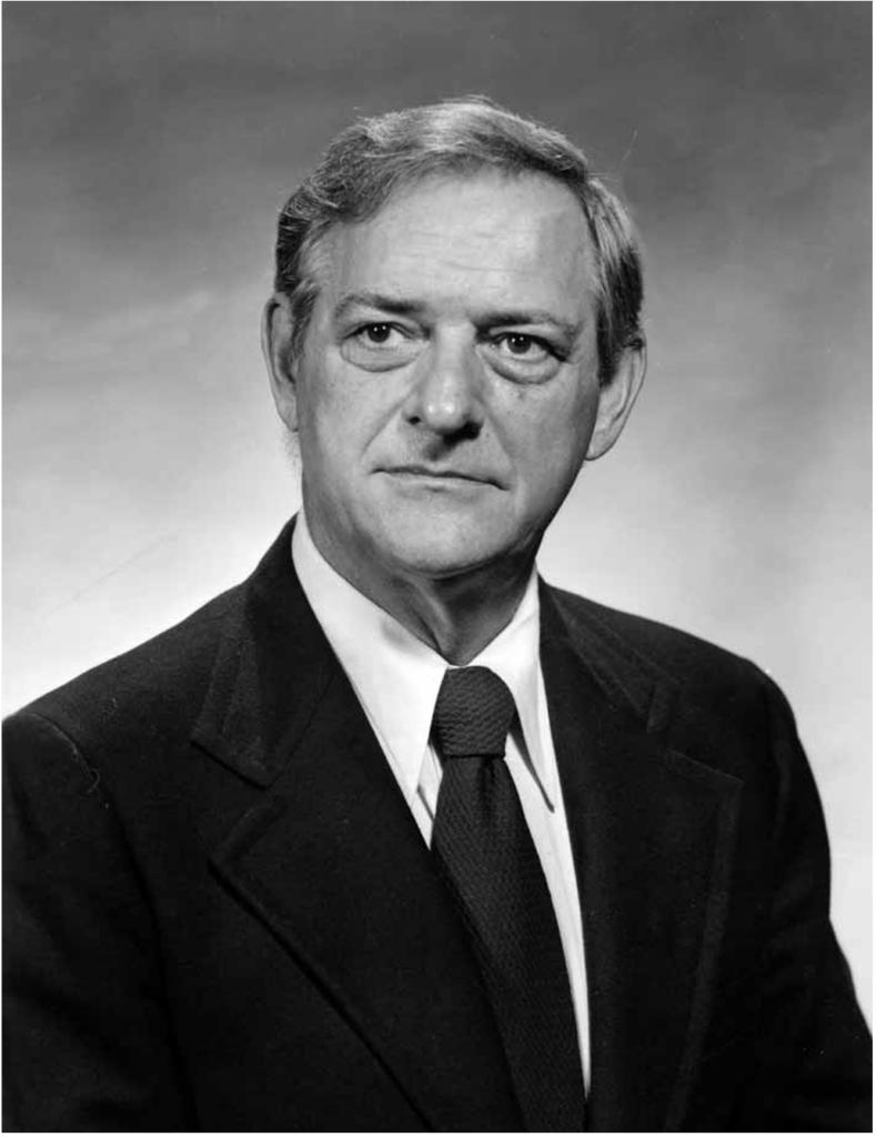 Columbus Clark. Serious face, short hair, suit and tie