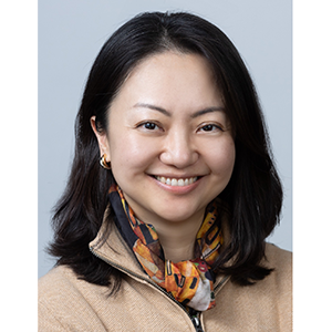 Portrait of Ruixiao Lu, a woman with a big smile, dark brown shoulder-length hair, and a scarf around neck 