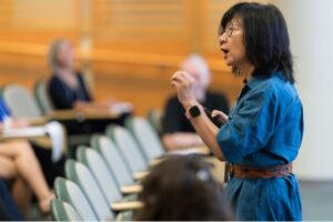 Ji-Hyun Lee speaking in front of class of students
