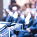 Public speaker at business conference, corporate presentation, workshop, coaching training, news conference, company meeting, public or political event