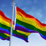 Rainbow flag waving on a clear day. Multicolored flag with stripes in the colors of the rainbow, often used as a symbol of LGBT pride. 3d illustration render. Fluttering fabric