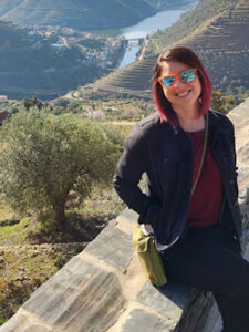 A white woman wearing sunglasses poses outdoors