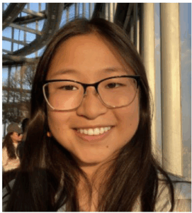 Portrait of Angela, big smile, glasses, long dark hair