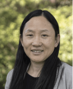 Portrait of Xue, female, long hair pulled behind ears, big smile