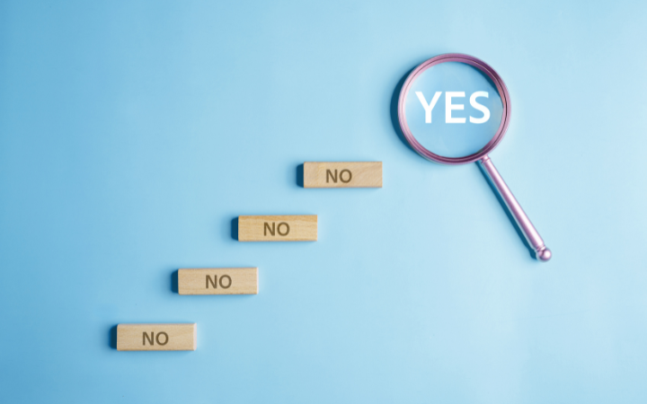 Magnifying glass shows the word YES really big, under it is five blocks that say no