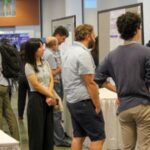 a group of people looking at posters at a conference
