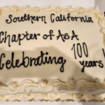 A white-frosted cake reading "Souther California Chapter of ASA Celebrating 100 years!