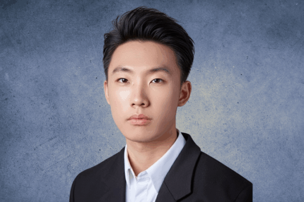 dark hair, no smile, suit jacket, collared shirt.