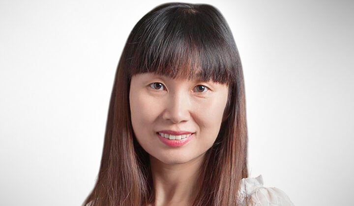 Devon Lin's headshot - dark brown hair with blunt bangs, smiling at the camera
