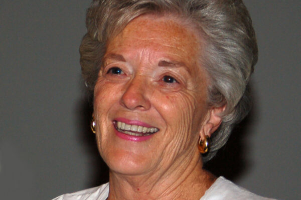 Short, gray hair, curled back, big smile