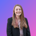 A young white woman with long, pink-streaked brown hair, wearing a black suit jacket and smiling widely