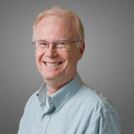 Photo of Barry, light blond hair, glasses, big smile