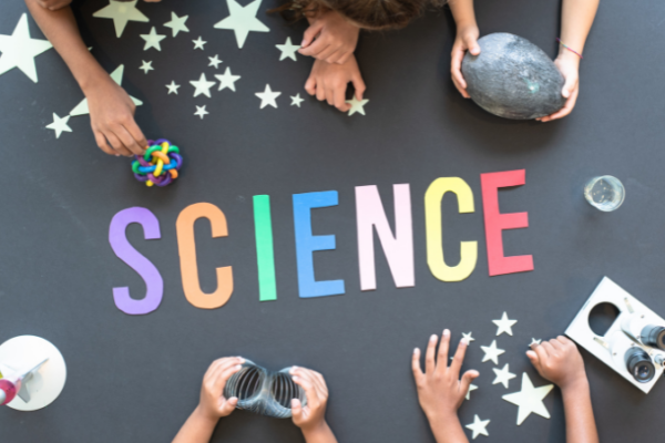Kids hands around the word science