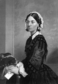 Florence Nightingale poses for a photo wearing a black dress and a white bonnet with short, dark hair.