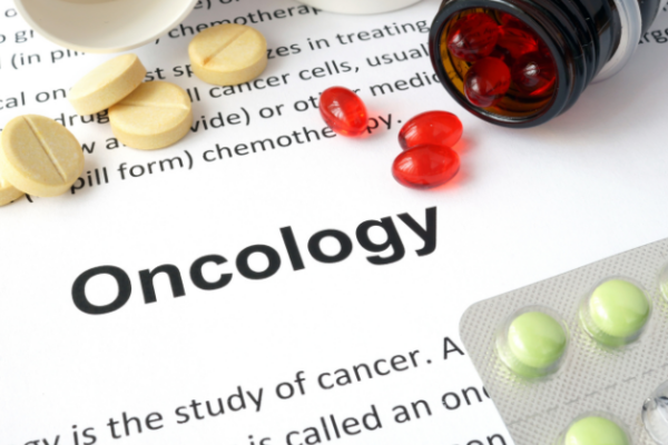"Oncology" surrounded by various pills and medications.