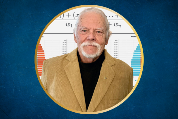 A white man in a tan sportcoat and a black shirt with a white beard