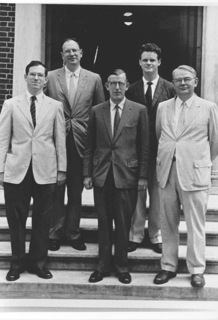 Black and white photo of five men in 1950s suits