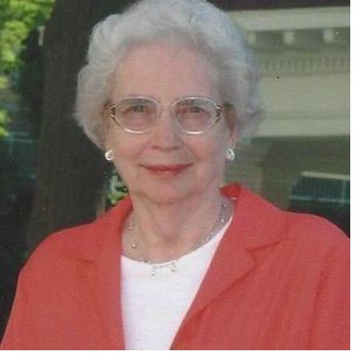 A white woman with white hair and a red jacket