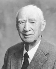 A man with white hair and a suit 