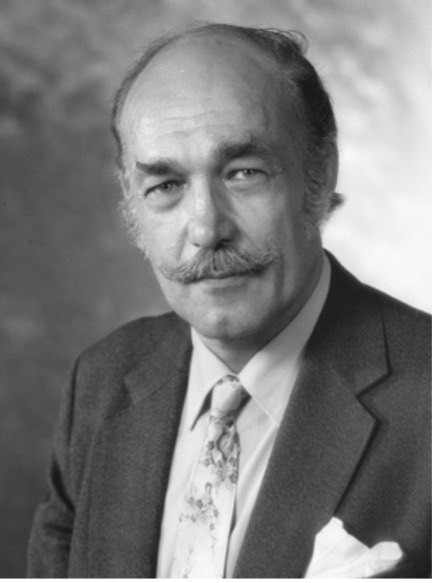 A man with a mustache wearing a suit and tie