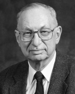 A bald man wearing glasses and a suit and tie