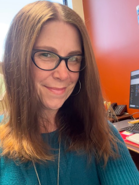 Glasses, long hair, slight smile